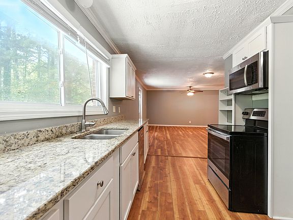 Sunlit Kitchen with brand-new stainless steel appliances. The wide kitchen window brings the outdoors in, filling the room with light and letting you stay connected to the family as you cook.