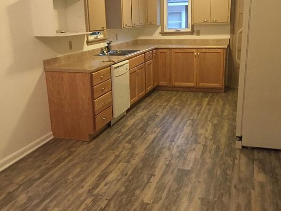 New flooring, lower cabinets and plumbing. Area for kitchen 