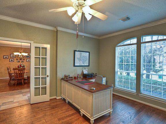 Spacious study with French doors and wood flooring.