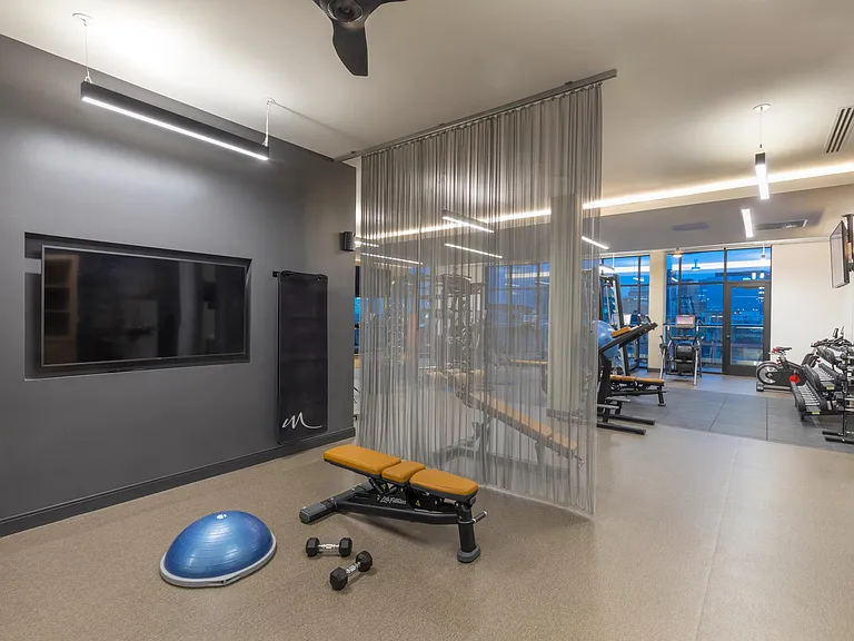 Fitness center with virtual fitness area and a variety of equipment.