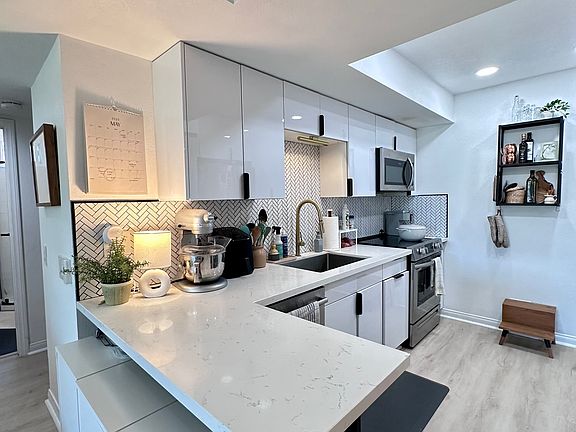 Kitchen view from peninsula (unit unfurnished, no cabinets under peninsula, room for chairs and seating)