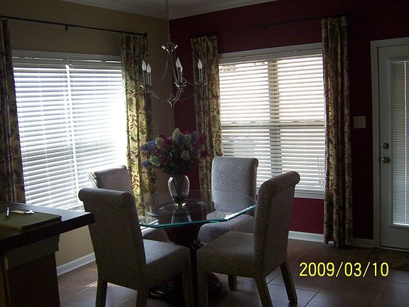 Dining room with tile flooring, window coverings.
