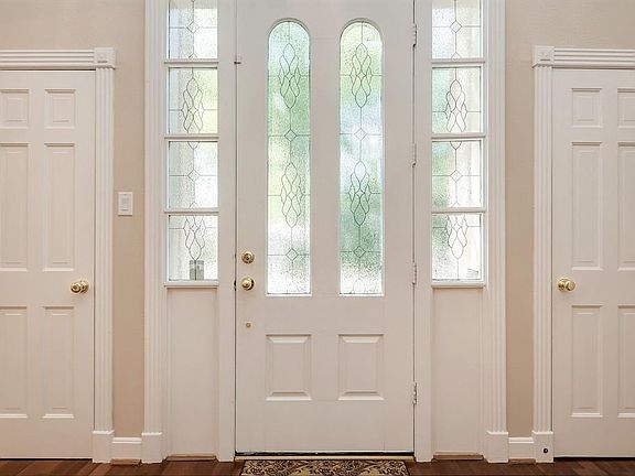 The foyer has two coat closets and a nice solid wood door with leaded glass inserts.