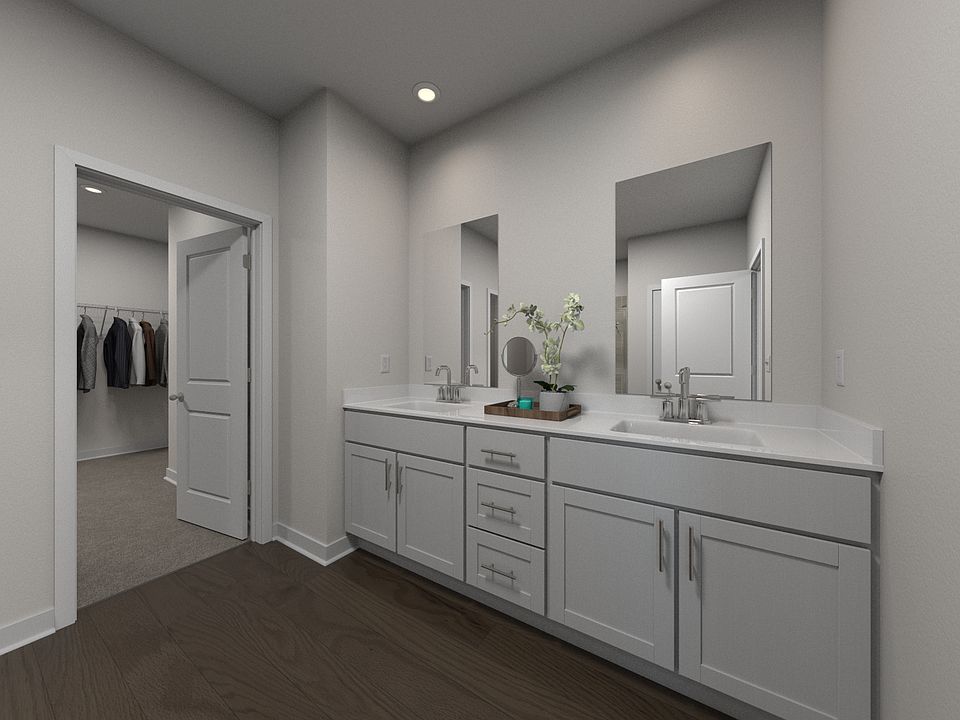 The primary bathroom offers dual vanity sinks and a walk-in shower.