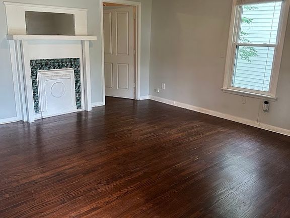 Walk into a spacious living room with beautiful hardwood floors and plenty of natural light.