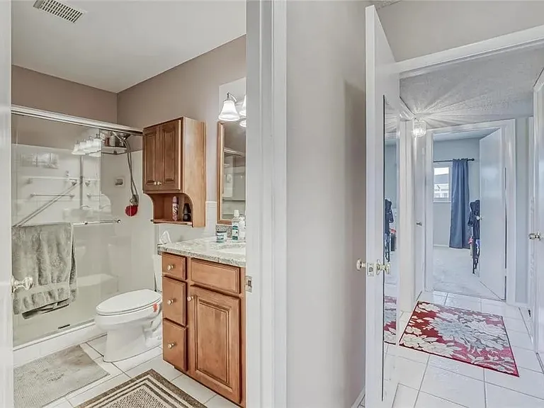 Master bathroom has a walk-in shower with safety bars, sink, medicine cabinet