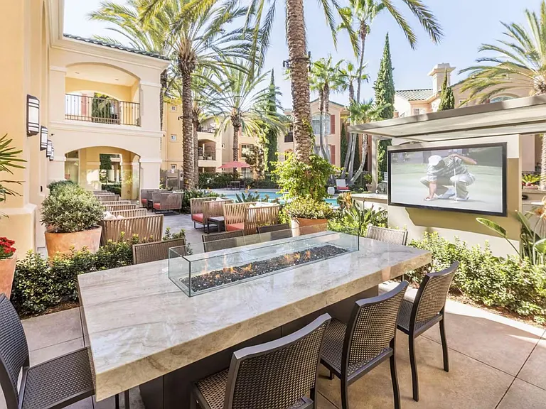 On-property resort-style fire table with poolside seating, landscaped grounds, and a shaded lounge area with TV and wifi.