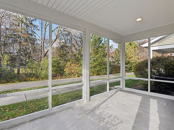 Screened in porch is wonderful living space for summertime enjoyment.