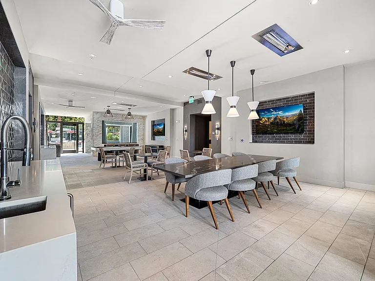 Clubroom with long dining table, seating, and entertainment