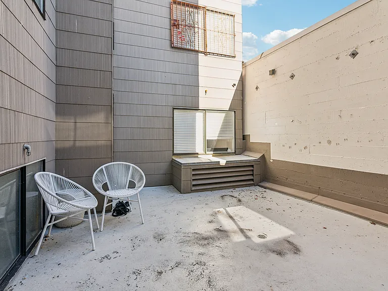 Enclosed outdoor patio area with round chairs
