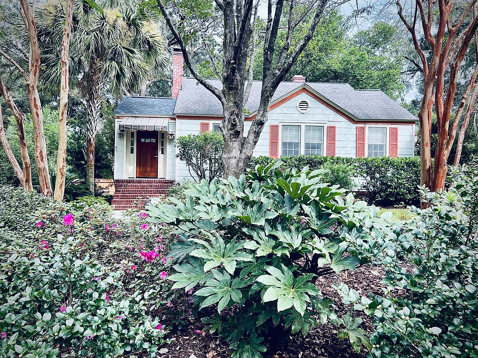 Front exterior + established garden beds include azaleas, fatsia, Mexican petunias, hydrangea