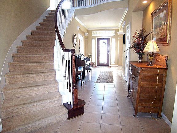 Grand foyer is over 25' long boasting a lovely curved stairway, tile floors and crown molding.