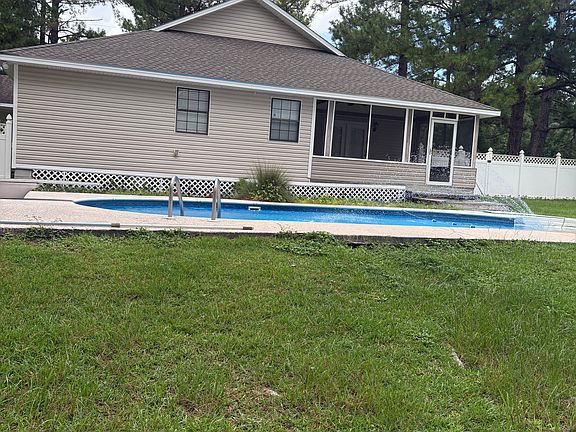 Backyard oasis with 8-ft inground pool, spacious screened porch, and ceiling fan for year-round comfort. Perfect for relaxing or entertaining in a private, shaded setting.