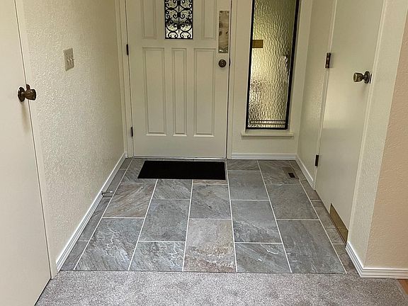 Front door entryway with door to garage.