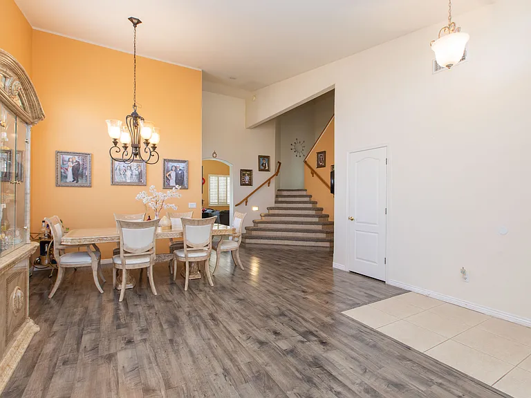 Spacious dinning & living room featuring bifurcated staircase leading upstairs