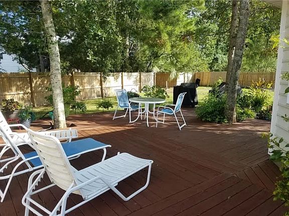 Expansive wrap around deck out the doors of the Sunroom with tree shade