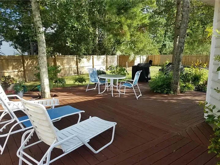 Expansive wrap around deck out the doors of the Sunroom with tree shade