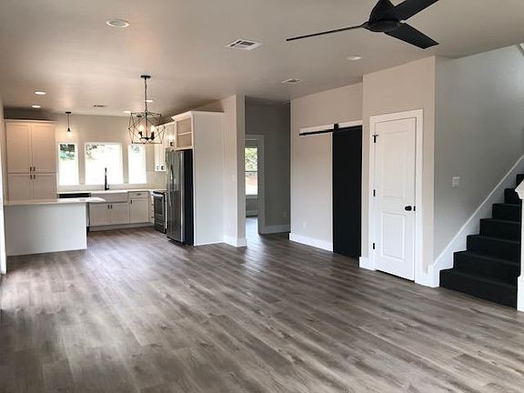 Open floorpan with patio door on the left to the private backyard. Behind the sliding chalkboard barn door is the washer and dryer. Understair storage in the closet next to stairs and rear small bedroom/office and half bath.