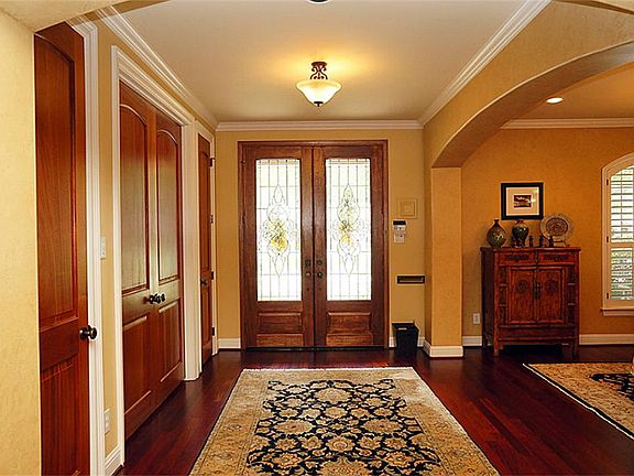 Gracious entry, open to the dining room and spacious den, with gleaming hardwood floors, crown moldi