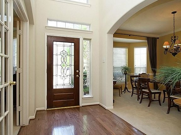 THE 2-STORY ENTRY HALL IS AN UPDATED CLASSIC WITH GLEAMING HARDWOOD FLOORS, SPINDLE BALCONY ABOVE, WIDE ARCHWAY TO ANNOUNCE THE FORMAL DINING ROOM, AND DIVIDED LIGHT GLASS FRENCH DOORS LEADING TO THE DEDICATED STUDY.