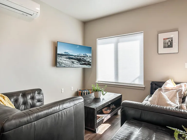 Flat screen smart TV, games and seating adjacent to kitchen and dining.