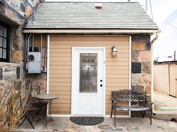 Entryway patio features Wrought Iron Bistro Set and Bench with access to private yard in rear.