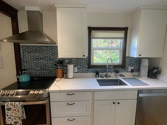 Remodeled kitchen with new stainless-steel appliances, including a dishwasher.