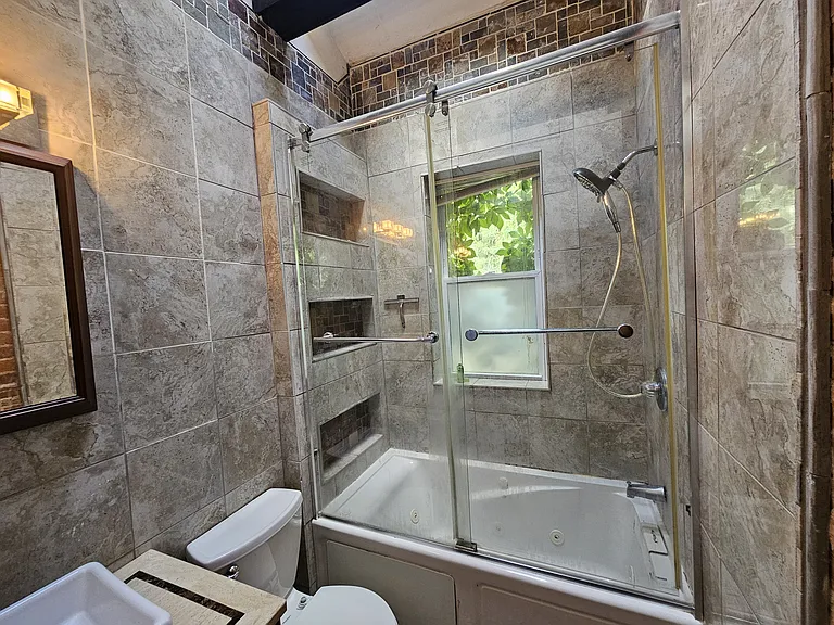 Tile shelving for the shower and large modern sliding shower doors.