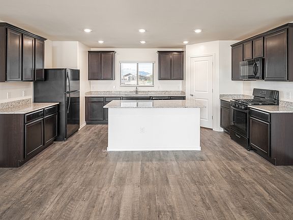 Actual home includes stainless appliances, granite countertops, and wood-style flooring.