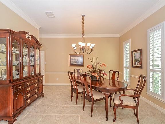Formal dining room has easy access to the kitchen. Entertaining friends and family is a breeze in this elegant room! Chair rail molding and crown molding add character to the room. Plantation shutters.