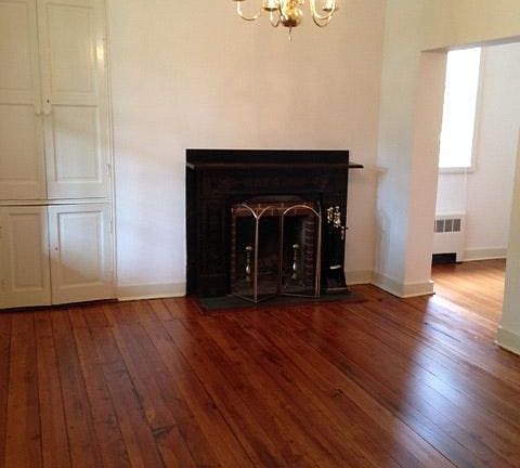 Living room with original hardwood floor and woodwork.