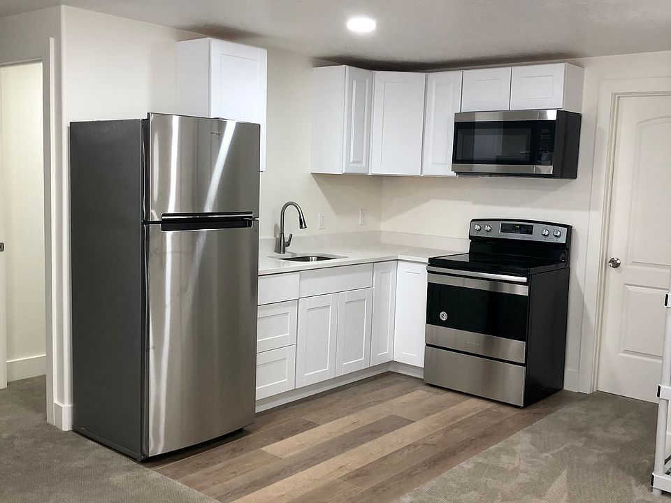 Kitchen with large refrigerator, standard sinks, oven, microwave & disposal_ no dishwasher. Small pantry with shelves & storage under stairwell.