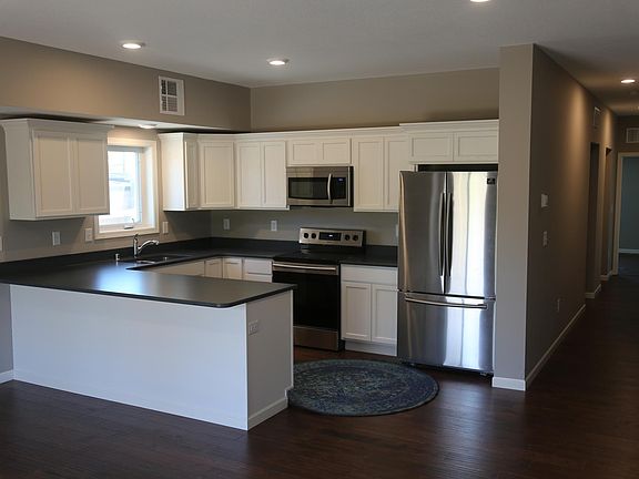 Open-concept living room and kitchen with high-top counter peninsula perfect for bar stools.