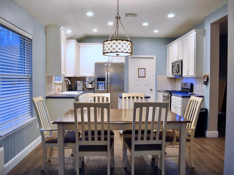 dining area with kitchen in background (fridge, dishwasher and gas stove/range included)