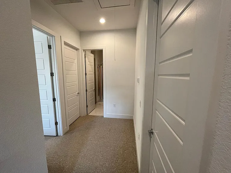 Upstairs Landing area. Primary Bedroom to immediate left, Laundry room to far left, secondary full bathroom straight, secondary bedrooms to immediate right (only one of the doors pictured, but the other is right next to it)