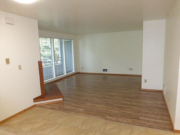 Spacious living room with lovely wood floors and big windows for light.
