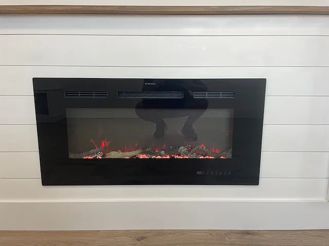 Fireplace finished in ship lap. Produces heat as needed. Touch glass for controls