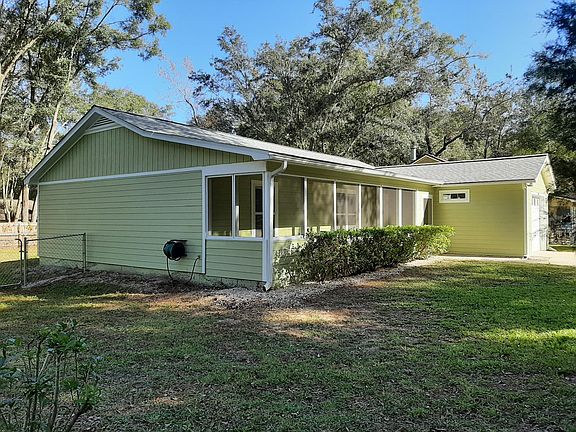 Side of house with fence, hose reel, front porch and garage view