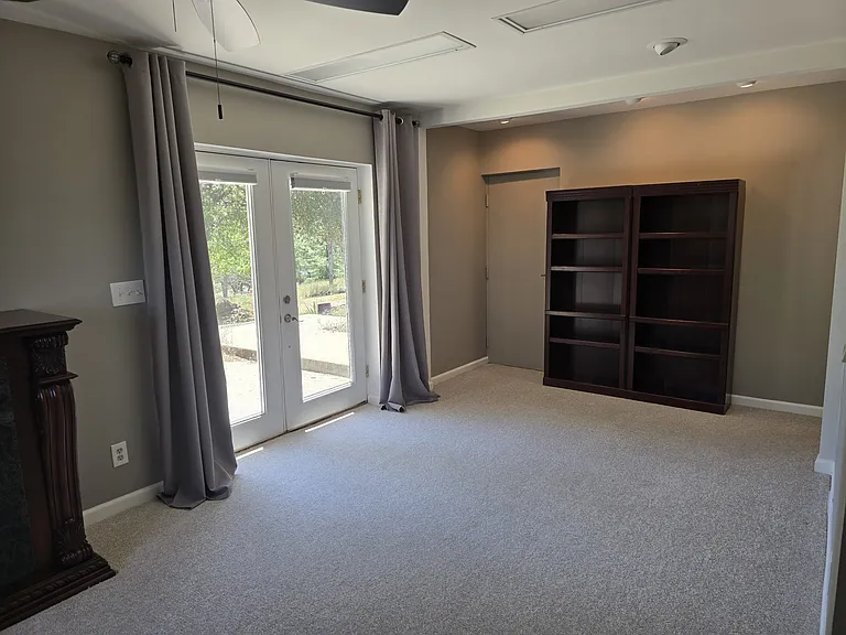 Living Space: Private French door entrance with custom room-darkening shades. Propane Fireplace and double bookcase, ceiling fan.