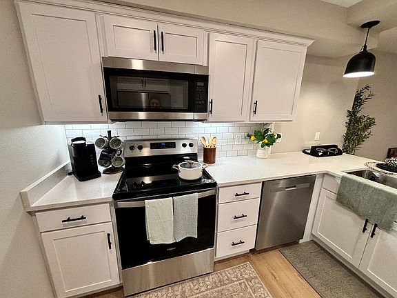 Kitchen featuring luxury vinyl plank, quartz countertops and stainless steel appliances