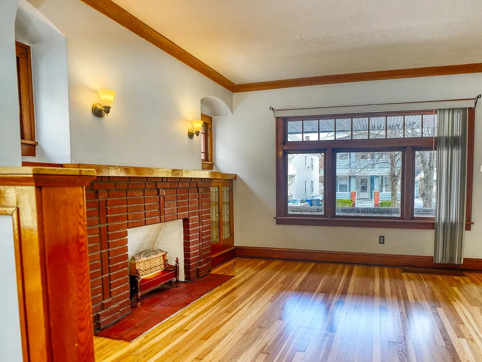 Living Room with updated lighting, decorative fireplace, built-ins, and freshly refinished original 1926 White Oak floors