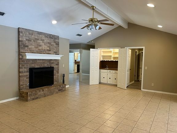 family room with wood burning gas fireplace and bar area with bifold doors
