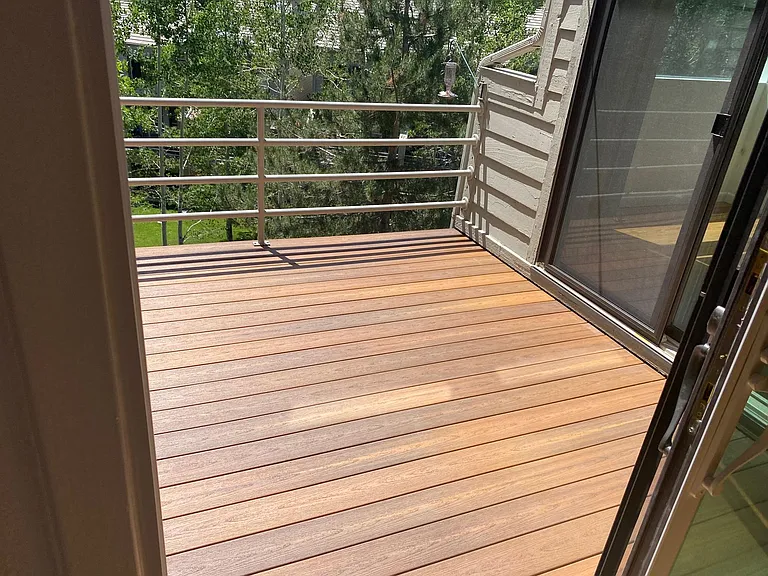 Deck with composite decking overlooks seasonal stream.