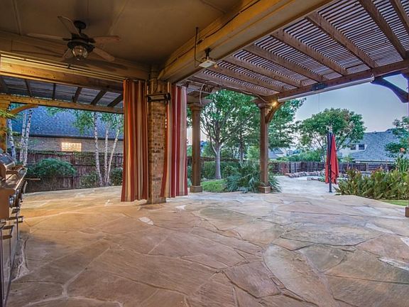 Huge Outdoor Living is Highlighted with Gas Grill, Drapes, Lots of Space for Entertaining
