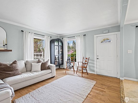 Spacious living room with crown moulding and hardwood floors>