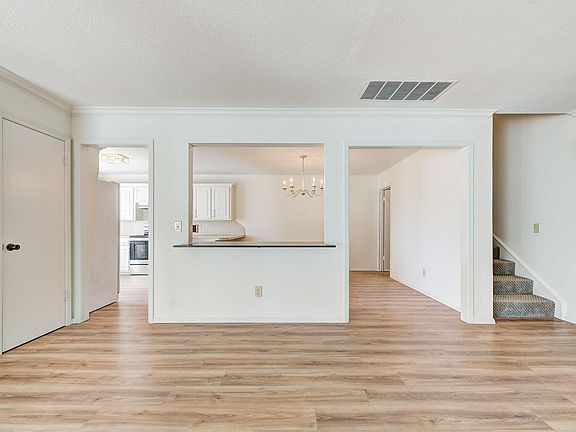 Living Room looking into Kitchen. The staircase leads to 2 Bedrooms & 1 Bathroom upstairs.