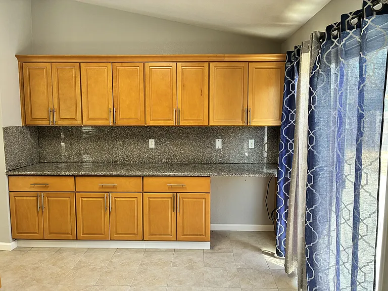Kitchen, other wall with cabinets and countertop + built-in workdesk.