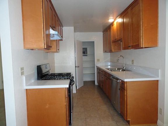 Kitchen with new quartz countertops, new range hood, new cabinets, and a pantry