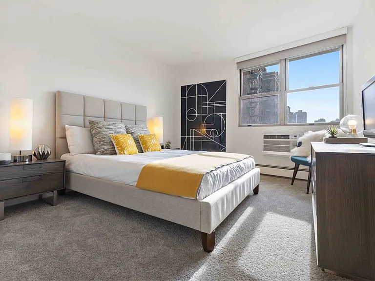 Large bedroom with plush carpeting and large windows