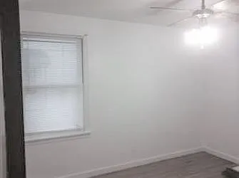 First floor bedroom or den - two windows, ceiling fan; this photo shows it unfurnished, next show with previous tenant's furnishings.